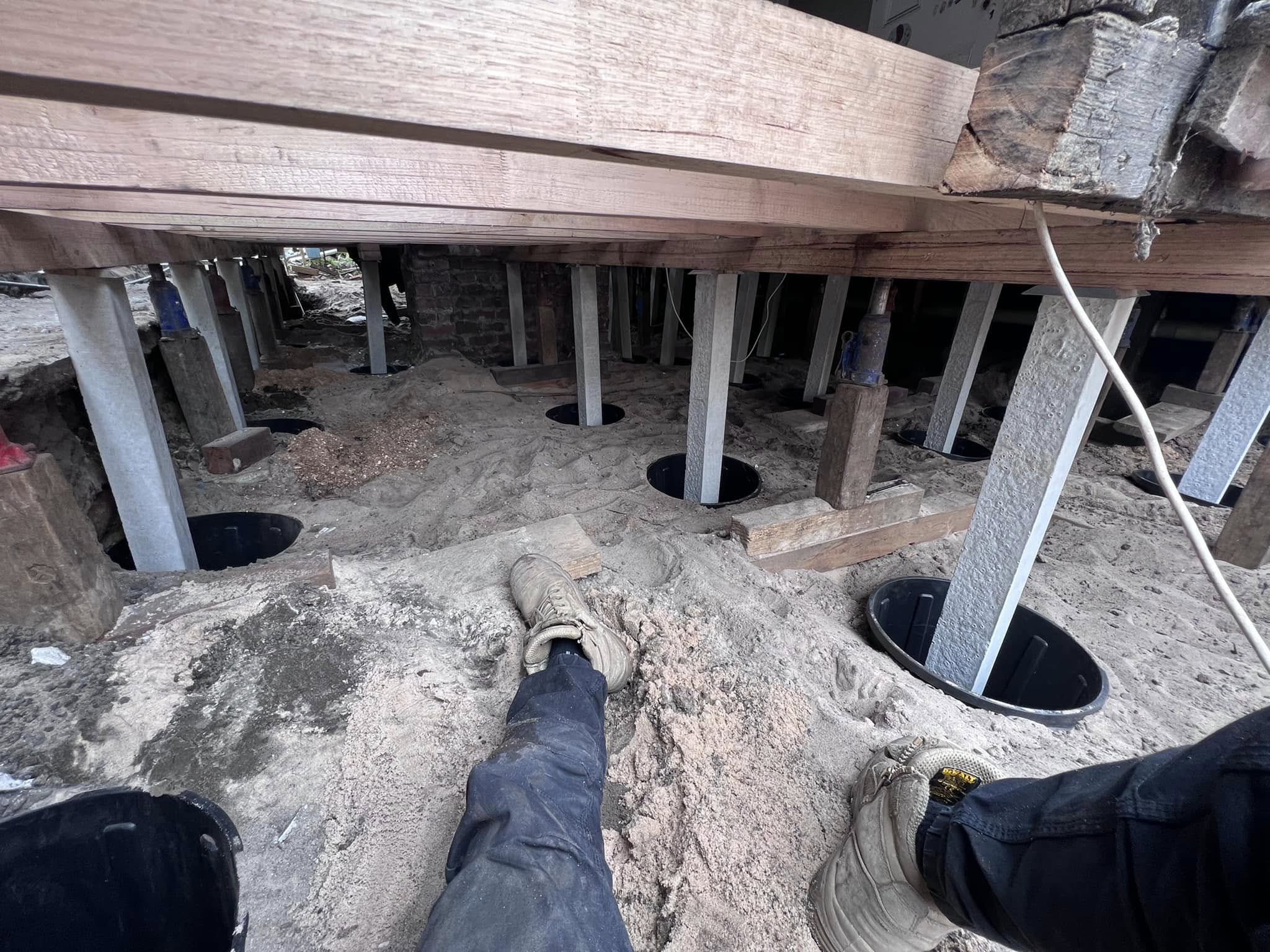 View under a house mid-reblock with new concrete stumps installed