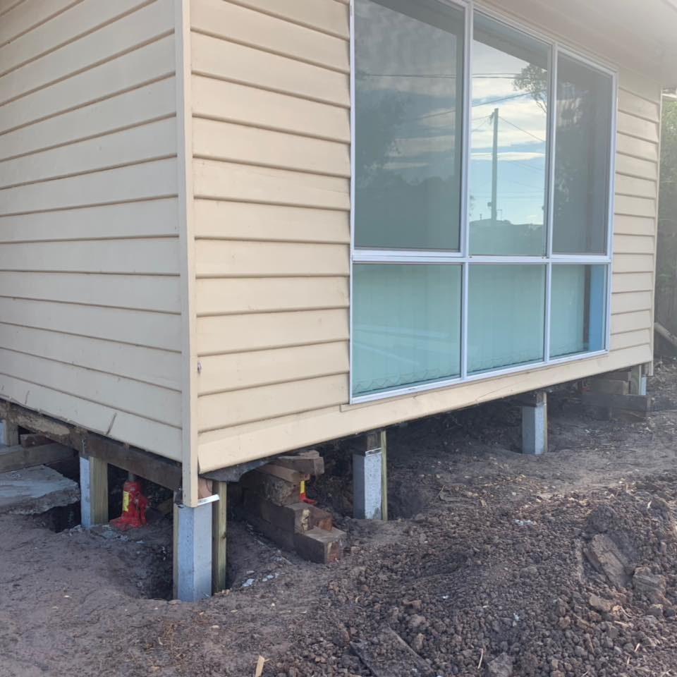 Corner of weatherboard home jacked clear of failed timber stumps