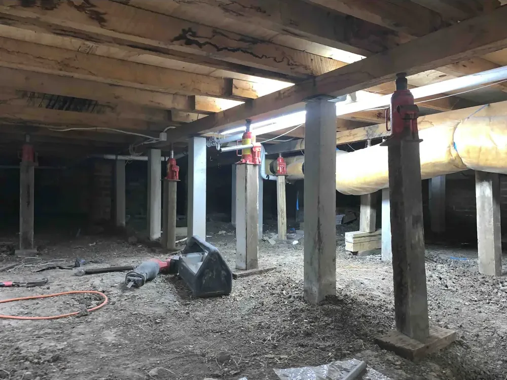 Hydraulic jacks supporting a weatherboard during levelling
