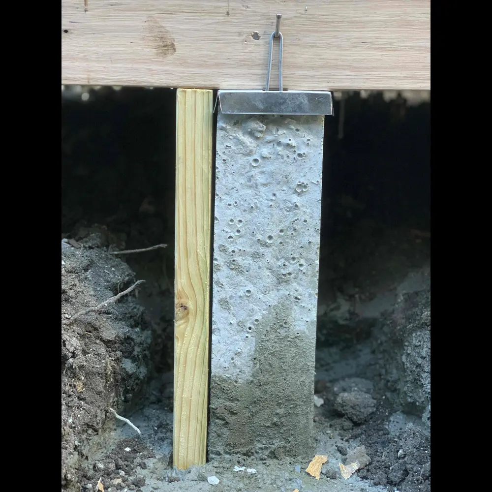 Old timber stump being replaced with a new concrete stump
